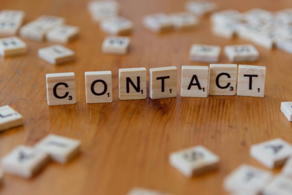 pexels photo 30901556 30901556 Scrabble letters spelling 'contact' on a wooden table surface.